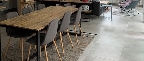 A modern living space with a staircase, dining area, and seating.