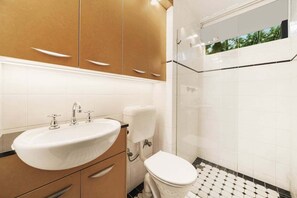 Ein Badezimmer mit Waschbecken, Toilette und Duschbereich.