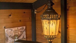 A wooden interior with a hanging lantern, a framed artwork, and a small rug on a wooden floor. - Moon Shadow (TOT ID #2164): 2  BR, 2  BA House in The Sea Ranch, Sleeps 4 (The Sea Ranch)