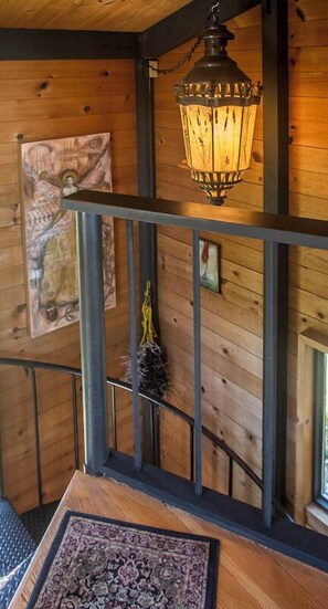 A wooden interior with a hanging lantern, a framed artwork, and a small rug on a wooden floor. - Moon Shadow (TOT ID #2164): 2  BR, 2  BA House in The Sea Ranch, Sleeps 4 (The Sea Ranch)