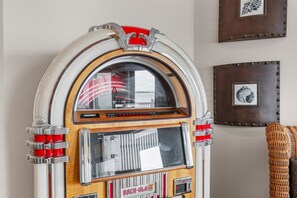 Un juke box con detalles de madera, adornos cromados y una parte superior roja.