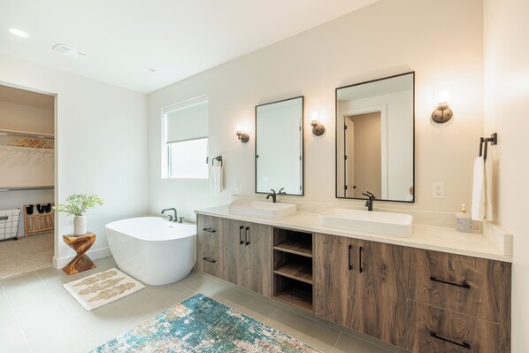 A modern bathroom with a freestanding bathtub, two sinks, and a large mirror. - Serenity on the 6th: 4 BR, 4 BA House in St. George, Sleeps 10 (St. George)