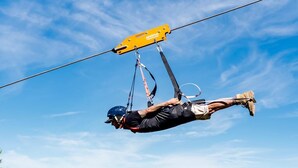 A person suspended in mid-air by a harness, with a mountainous landscape in the background. - Appartement 4 Personnes 31m² - Les Orres 1650 (Les Orres)