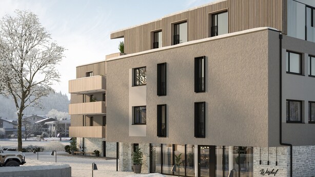 Ein mehrgeschossiges Gebäude mit moderner Architektur, inklusive Balkone und großer Fenster.