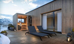 Ein moderner Außen-Loungebereich mit zwei Liegestühlen, einer Holzterrasse und Blick auf eine gebirgige Landschaft.