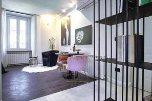 Una sala moderna con comedor, una reja de metal negro y un radiador blanco.