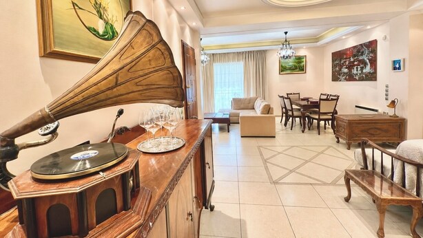 Un salón luminoso con un piano, un comedor y un sofá.