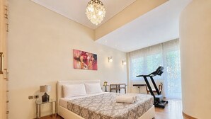 Un dormitorio con una cama grande, una cinta de correr y una ventana con vistas.