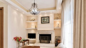 Amplia sala de estar con chimenea, televisor y un área de descanso confortable.