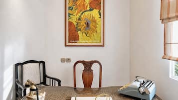 Een kamer met een bureau, een oude typmachine, een telefoon en een lijst met een schilderij.