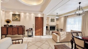 A spacious living room with a fireplace, a dining area, and a seating area with a sofa and chairs.