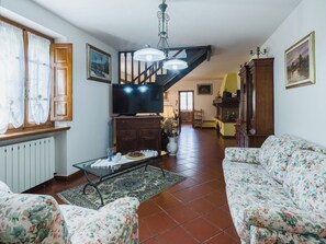A spacious living room with a staircase, a television, a sofa, and a dining area. - Beautiful private villa for 6 people with WIFI, private pool, TV, patio and pets allowed (Camaiore)