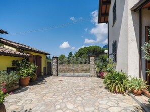A courtyard with stone flooring, a metal gate, and potted plants. - Stunning private villa for 6 guests with private pool, WIFI, TV, patio and pets allowed (Camaiore)