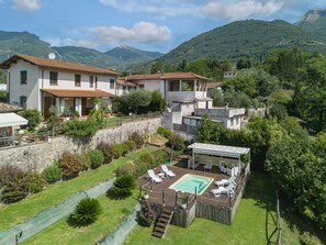 A residential area with a swimming pool, outdoor seating, and a stone wall. - Beautiful private villa for 6 people with WIFI, private pool, TV, patio and pets allowed (Camaiore)