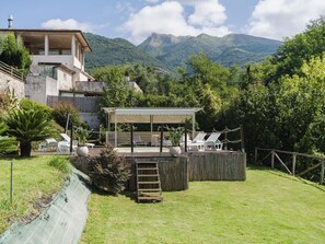 Eine Villa mit Pool, Sitzgelegenheiten im Freien und Bergblick.