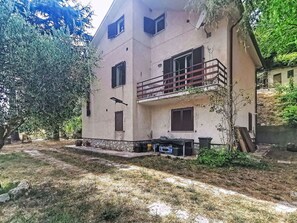 A two-story building with a balcony, stone foundation, and a garden area. - Stunning  villa for 5 people with hot tub, WIFI, balcony, pets allowed and panoramic view (Rocca Sinibalda)