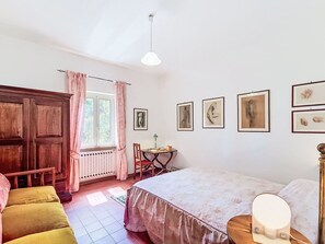 Ein Schlafzimmer mit einem Bett, einem Schreibtisch, einem Stuhl und einem Kleiderschrank.