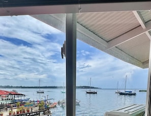 A view of a marina with boats docked and a covered area with potted plants. - The Jungle Hotel and Bar (Bocas del Toro)