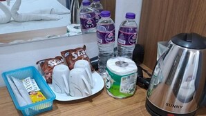 A wooden table with toiletries, including a coffee maker, bottled water, and personal care items. - SCK Guesthouse (Vang Vieng)