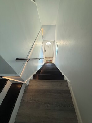 Una escalera con barandilla y una puerta al final.