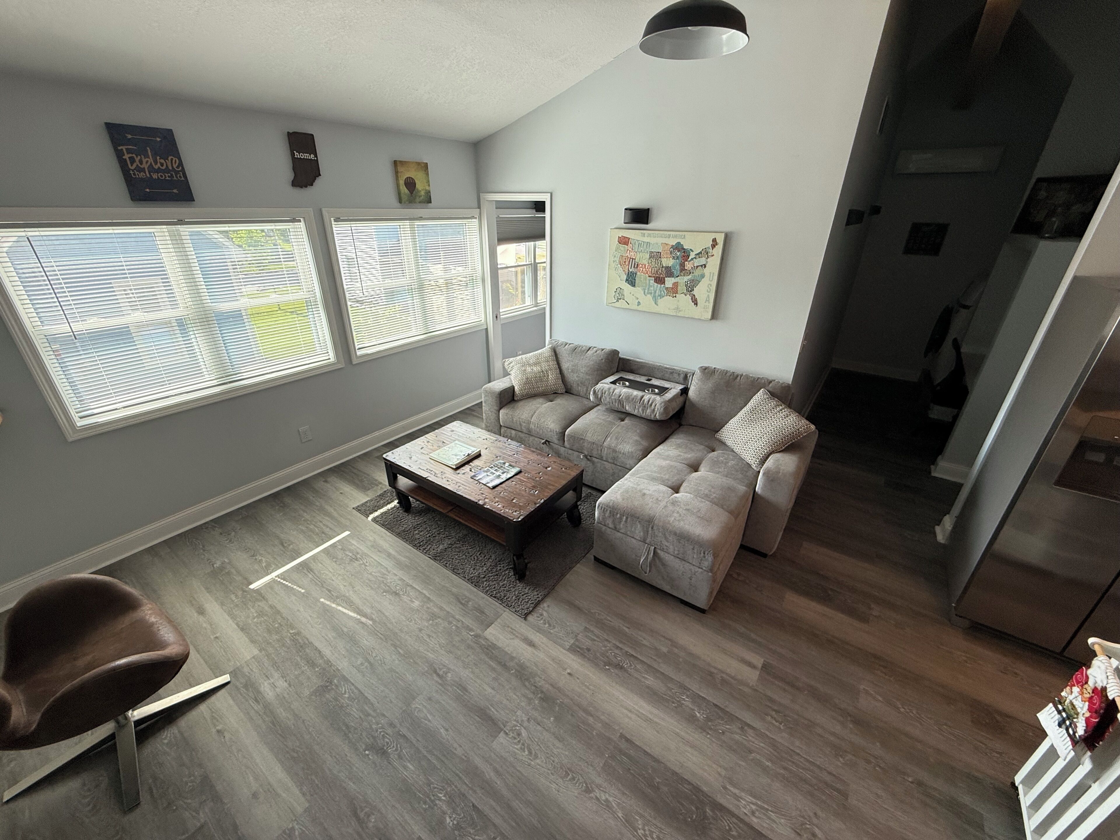Una sala de estar moderna con un sofá modular, una mesa de centro y ventanas amplias.
