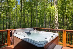 A hot tub on a wooden deck surrounded by a forest. - 3 Brothers Bears 3 Bedroom Cabin (Sevierville)