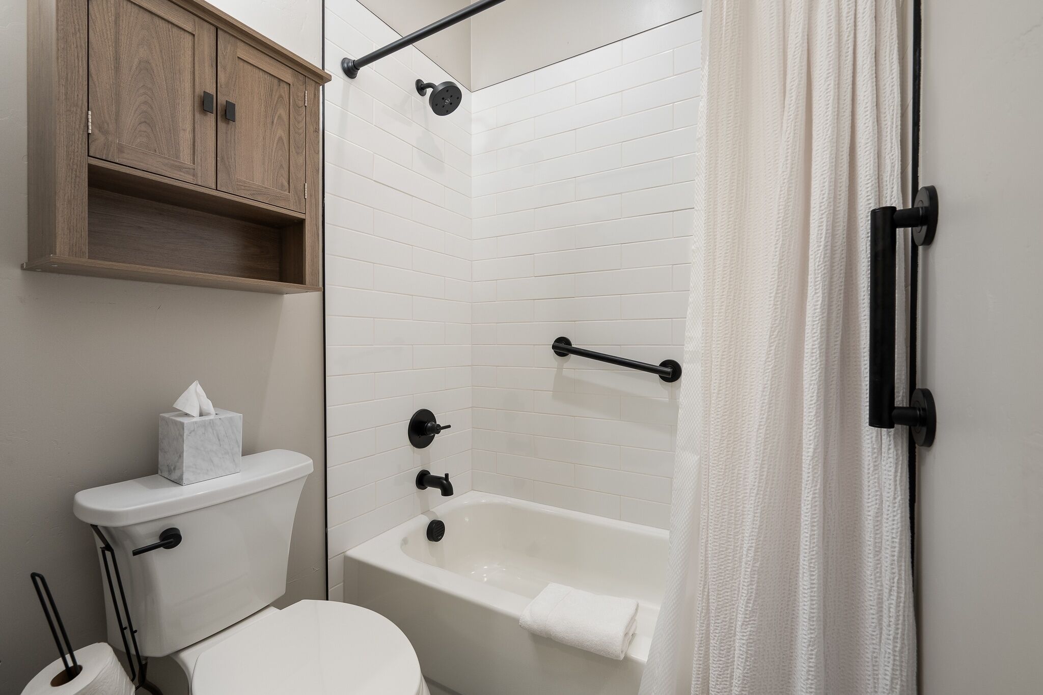 Ein Badezimmer mit Toilette, Badewanne und Duschbereich.