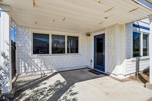 A residential building with a covered porch, a front door, and a window. - 733a Tarpon Avenue 3 Bedroom Apts (Fernandina Beach)