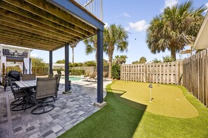 A covered patio area with a pool table, outdoor seating, and a well-maintained lawn. - 733a Tarpon Avenue 3 Bedroom Apts (Fernandina Beach)