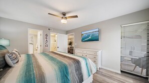A bedroom with a bed, a ceiling fan, a TV, and a window with blinds. - Fort Goyastein South 2 Bedroom Condo (Sarasota)