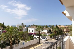 A coastal residential area with white buildings, palm trees, and a clear view of the sea. - Brisa & Mar, Las Chapas, 3-Bedroom (Marbella)