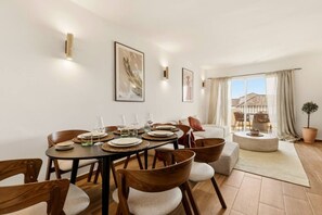 A dining area with a round table set for four, surrounded by wooden chairs. - Brisa & Mar, Las Chapas, 3-Bedroom (Marbella)