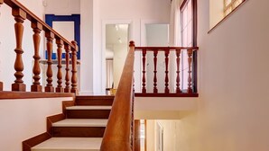 Una escalera de madera con barandilla que lleva a una plataforma.