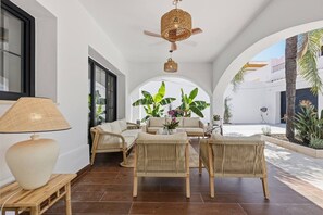 Un espace intérieur spacieux, aménagé avec des sièges, une lampe et un ventilateur de plafond.