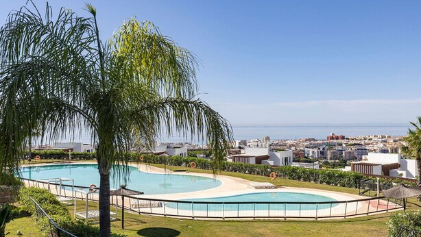 En swimmingpool med udsigt over byen og havet.