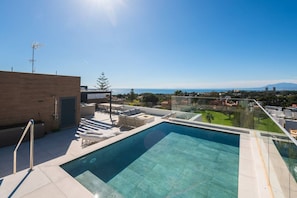 Ein Pool auf dem Dach mit freiem Blick auf die Stadt und die entfernten Berge.