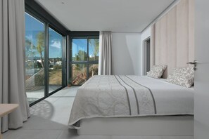 A bedroom with a large bed, a sliding glass door leading to a balcony, and a view of the outdoors. - Sky Penthouse with Private Pool (Artola)