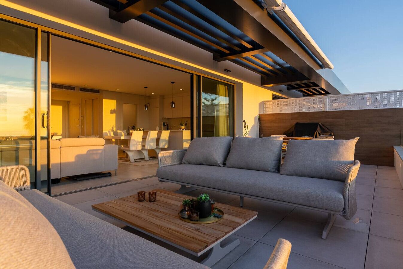 A modern outdoor living space with a sofa, chairs, and a coffee table.