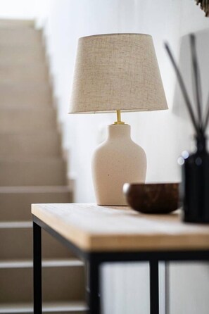 Um abajur com cúpula texturizada sobre uma mesa.