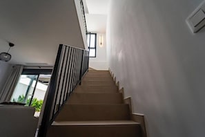 Uma escadaria com design moderno, que dá acesso a um andar superior.