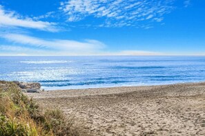 Ein Strand mit blauem Himmel und ruhiger See.