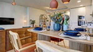 A modern kitchen with a central island, pendant lighting, and a flat-screen TV mounted on the wall. - PAZ House with Views and a Garden (Málaga)
