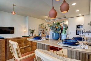 A modern kitchen with a central island, pendant lighting, and a flat-screen TV mounted on the wall. - PAZ House with Views and a Garden (Málaga)