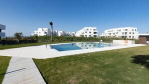 A modern residential complex with a swimming pool, a grassy area, and white buildings. - PAZ House with Views and a Garden (Málaga)