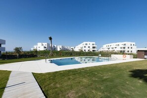 A modern residential complex with a swimming pool, a grassy area, and white buildings. - PAZ House with Views and a Garden (Málaga)