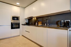 A modern kitchen with built-in appliances, a countertop, and cabinets. - PAZ House with Views and a Garden (Málaga)