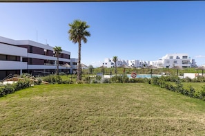 A modern building with a pool area, surrounded by greenery and palm trees. - PAZ House with Views and a Garden (Málaga)