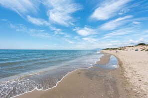 Ein Strand mit blauem Himmel und ruhiger See.