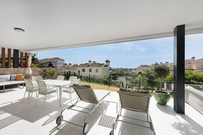 A spacious outdoor patio with a white table and chairs, a sofa, and a potted plant. - Venere Retreat: Serenity and Design (Marbella)