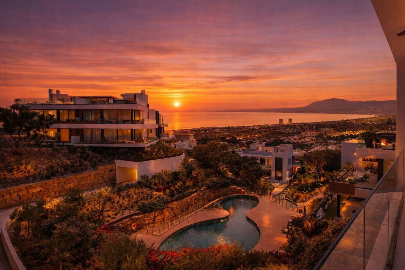 A modern resort with a pool, sunset views, and multiple buildings.